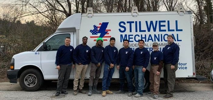 Group of men in blue shirts with the Stilwell Mechanical truck.