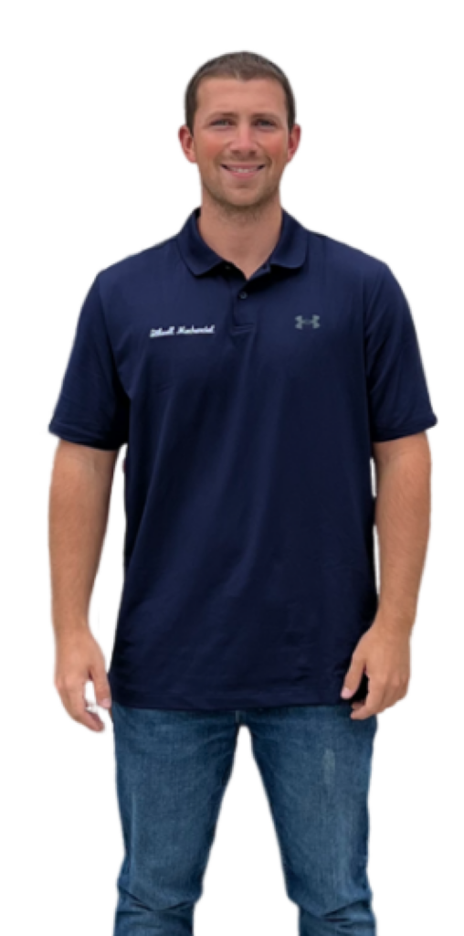 Man in navy blue polo shirt and jeans smiles.
