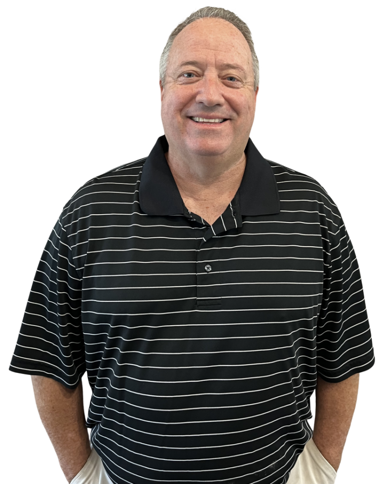 Man in a black and white striped polo shirt smiles, hands in pockets.