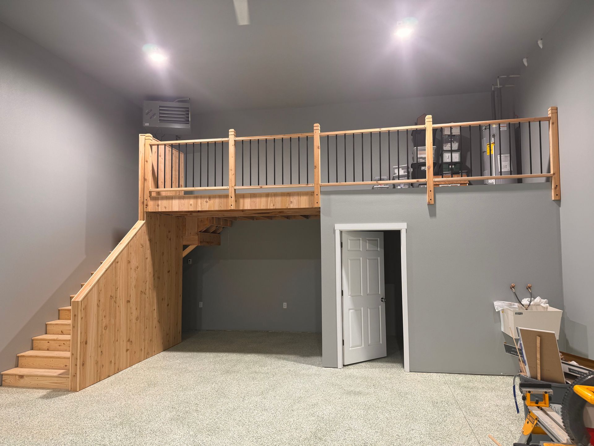 A room with a balcony and stairs in it.