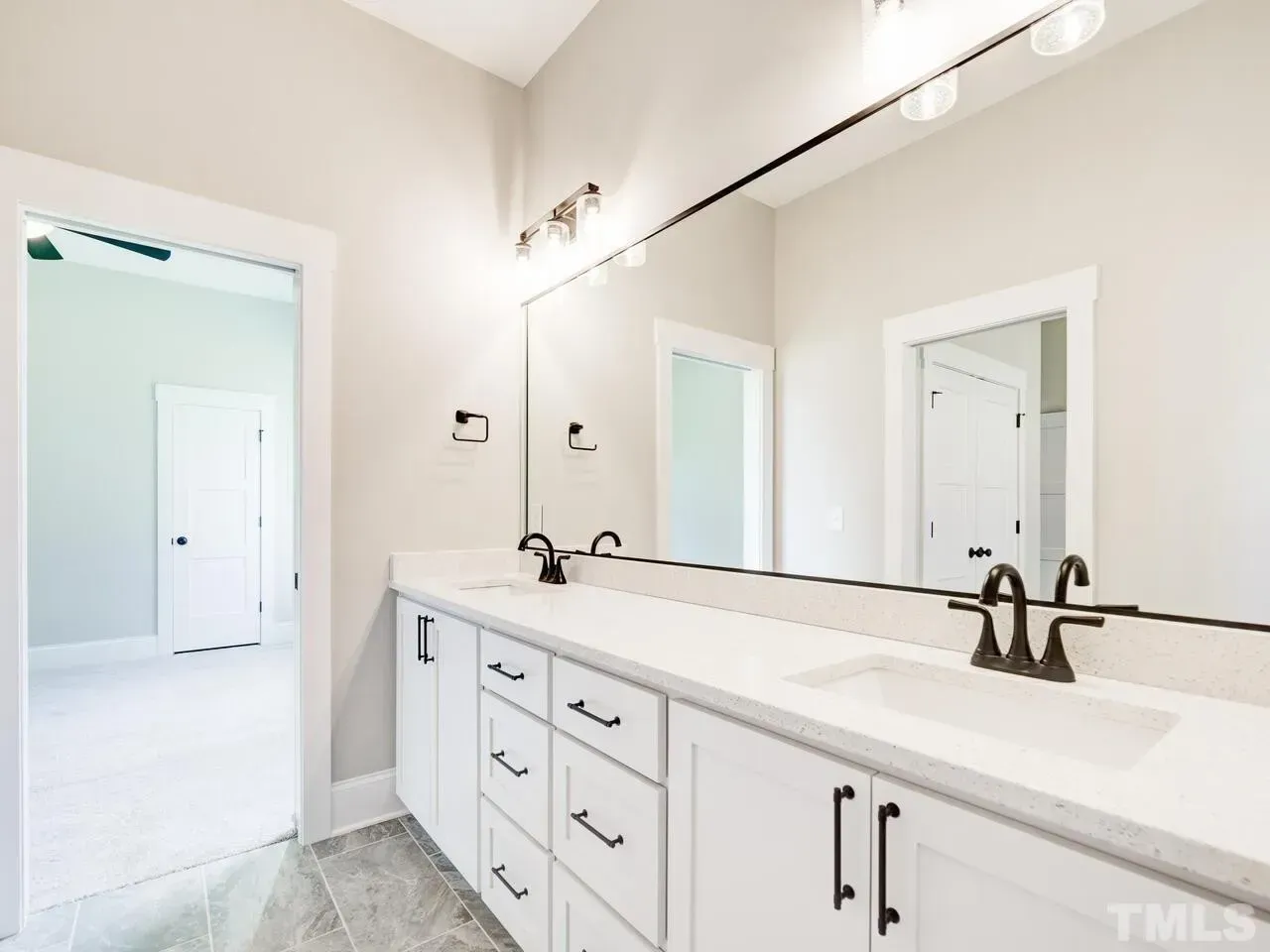 A bathroom with two sinks and a large mirror.