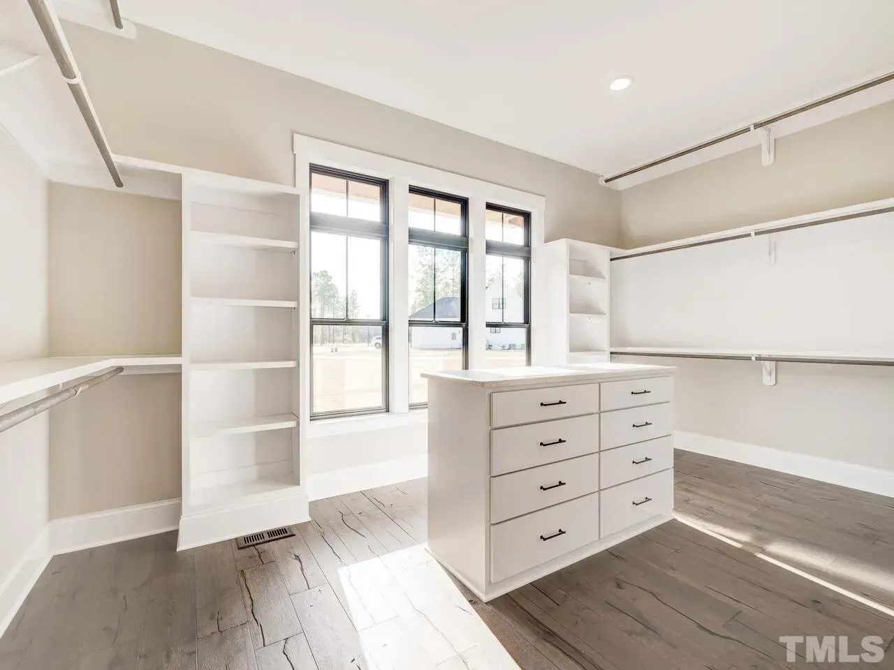 A walk in closet with lots of shelves and drawers