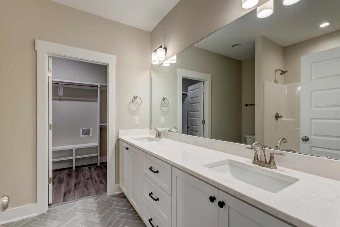 A bathroom with two sinks and a large mirror.
