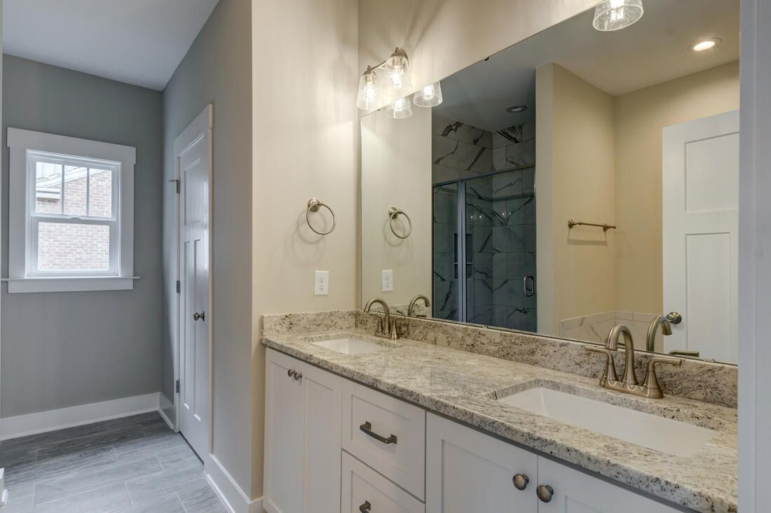A bathroom with two sinks and a large mirror.