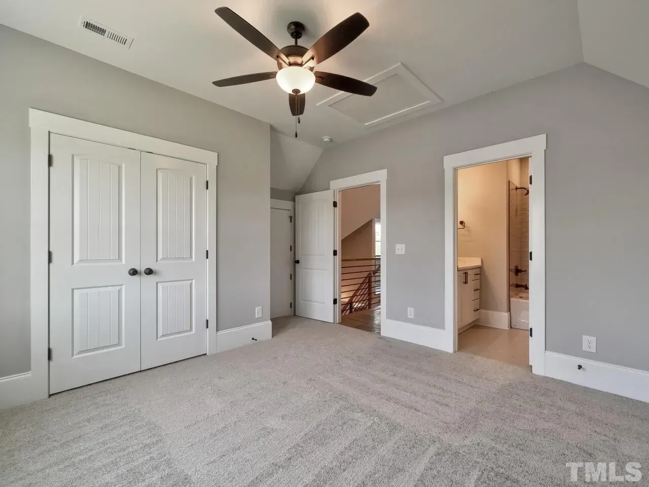 A bedroom with a ceiling fan and a tmls logo on the wall