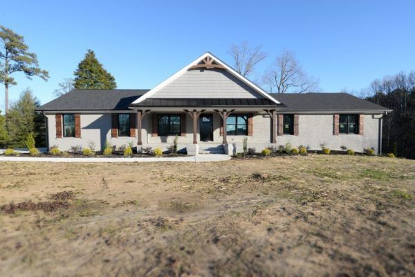 A large house is sitting on top of a grassy hill.