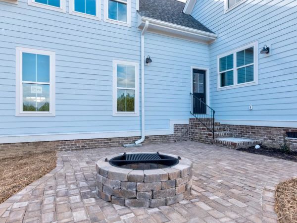 There is a fire pit in the backyard of a house.