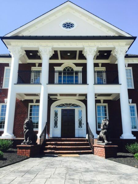 A large brick building with white columns and statues in front of it