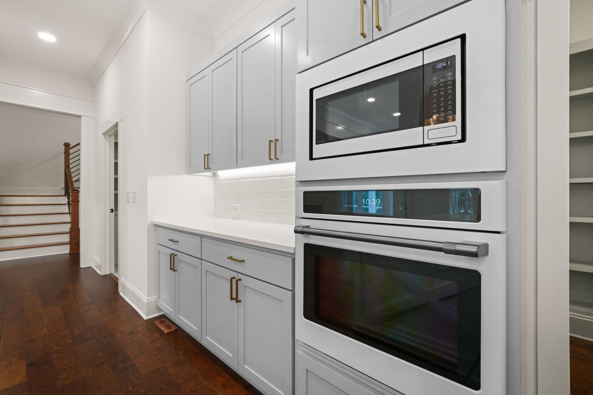 A kitchen with white cabinets and a microwave oven.