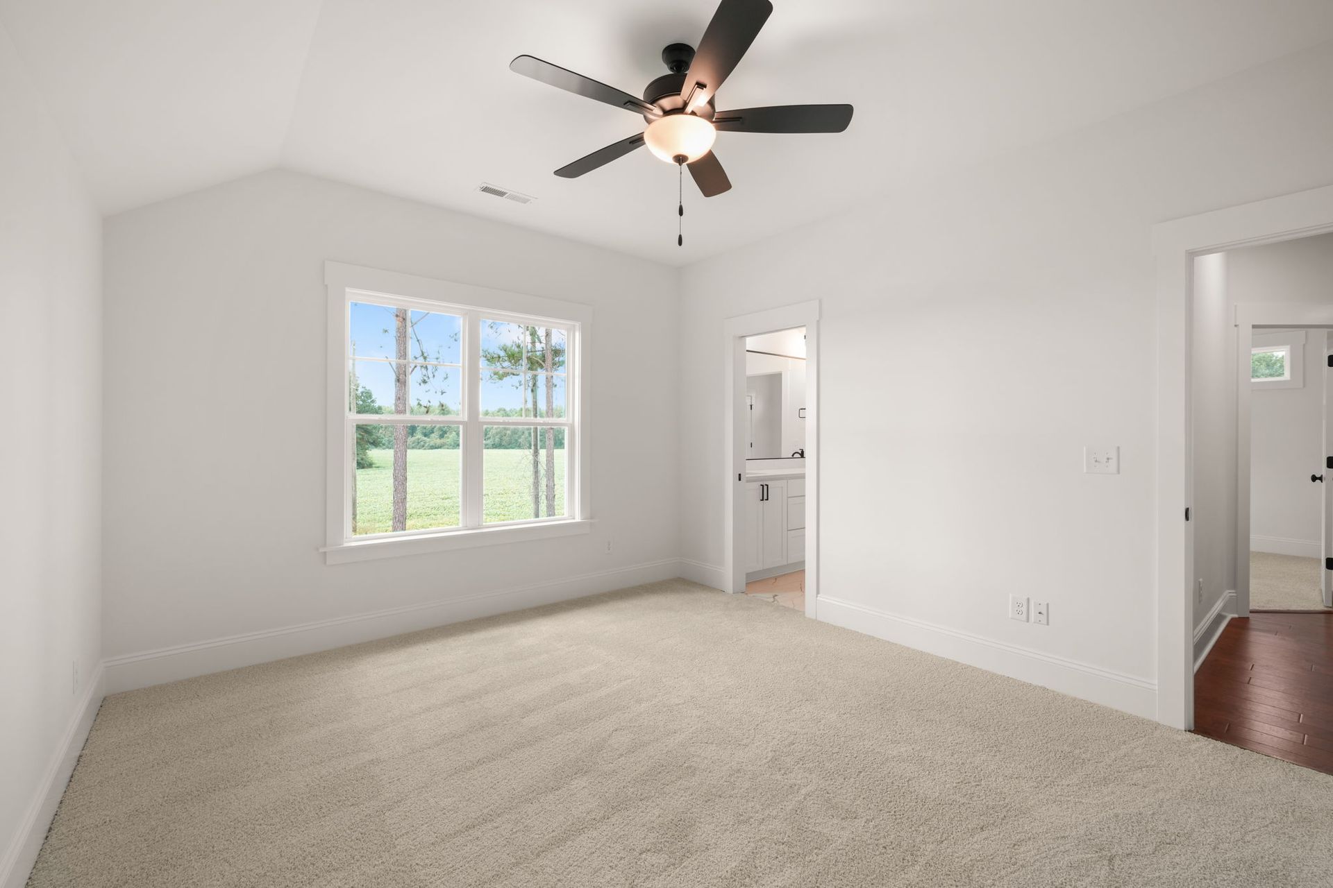 An empty room with a ceiling fan and a window