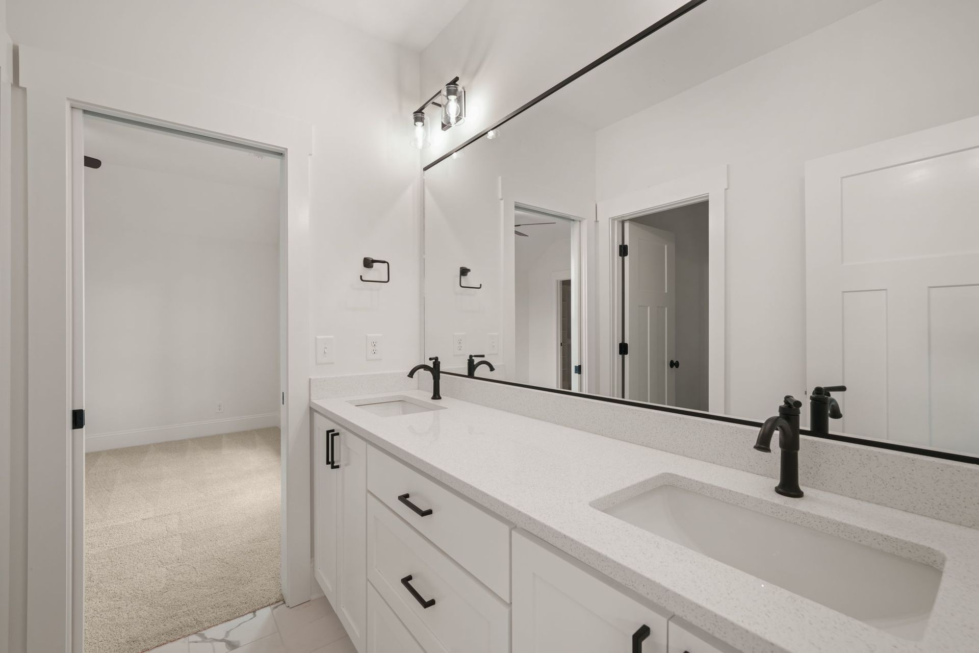 A bathroom with two sinks and a large mirror.