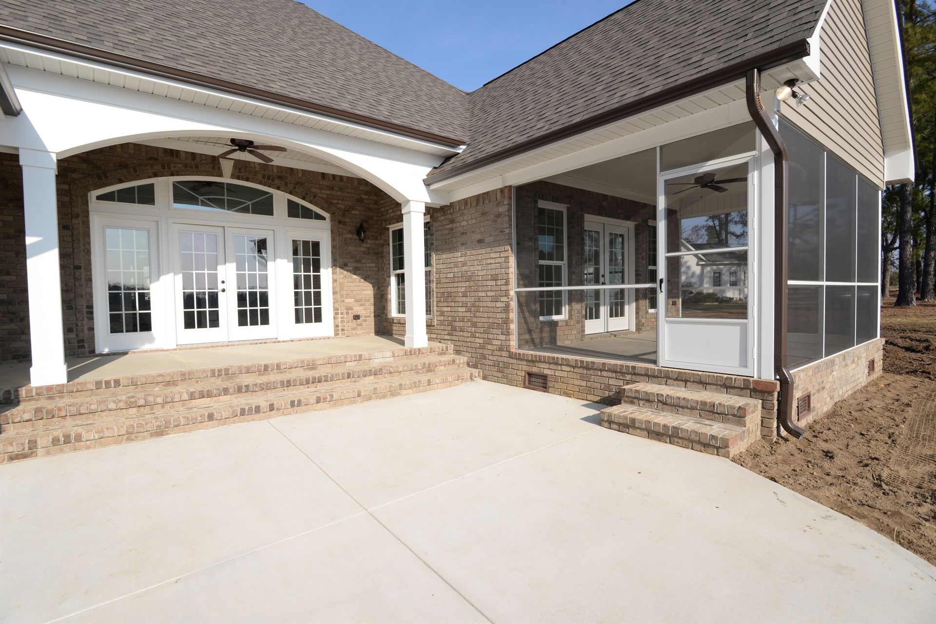 A large house with a screened in porch and stairs.