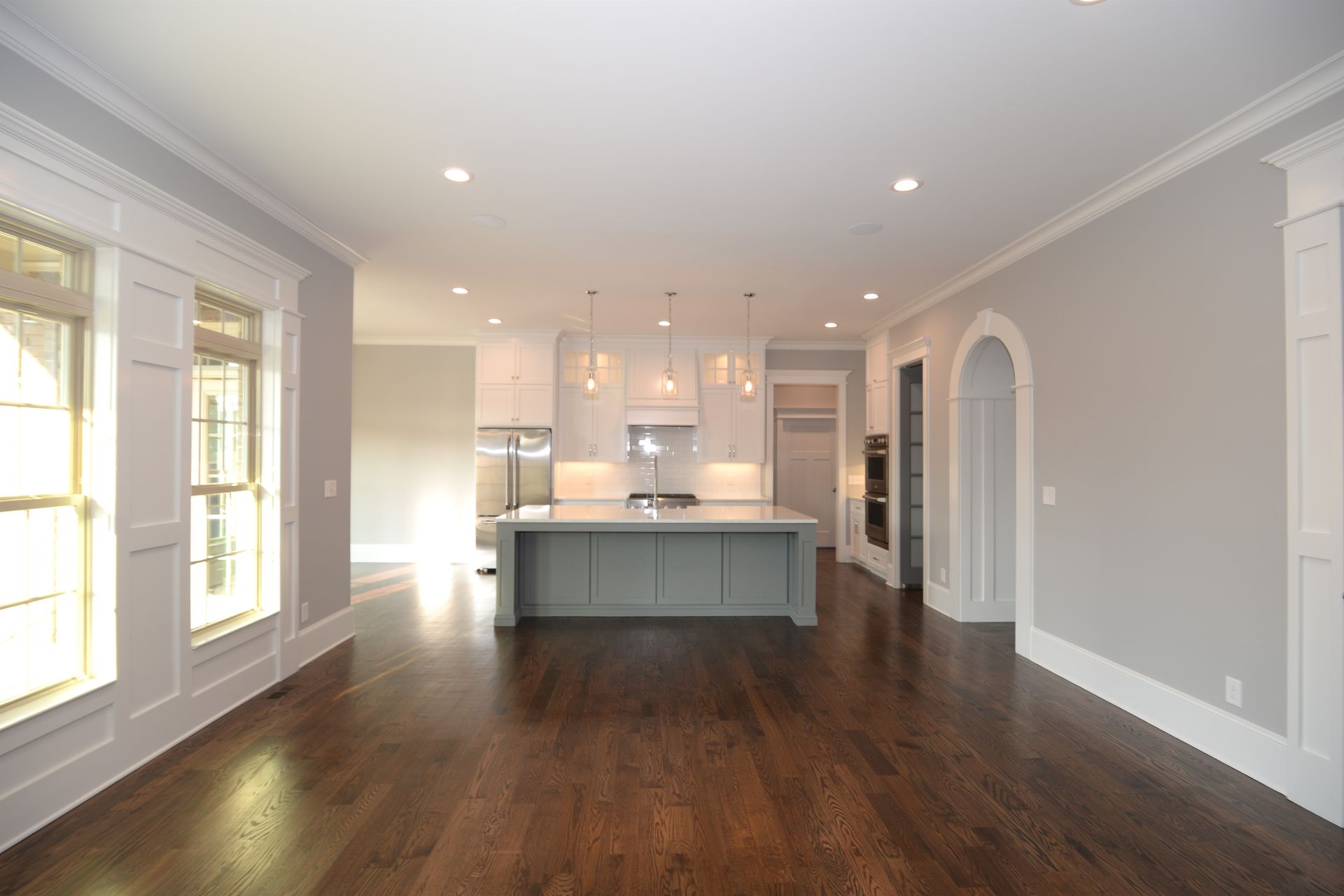An empty kitchen with a large island in the middle.