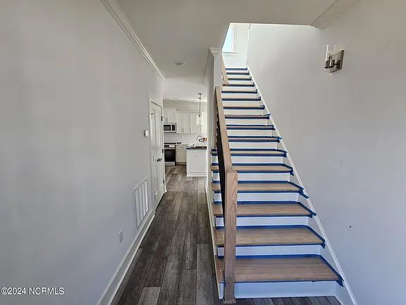 A hallway with stairs leading up to the second floor of a house.
