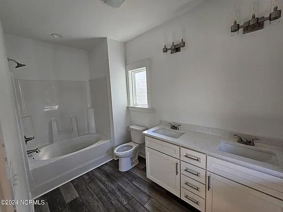 A bathroom with a tub, toilet, sink and shower.