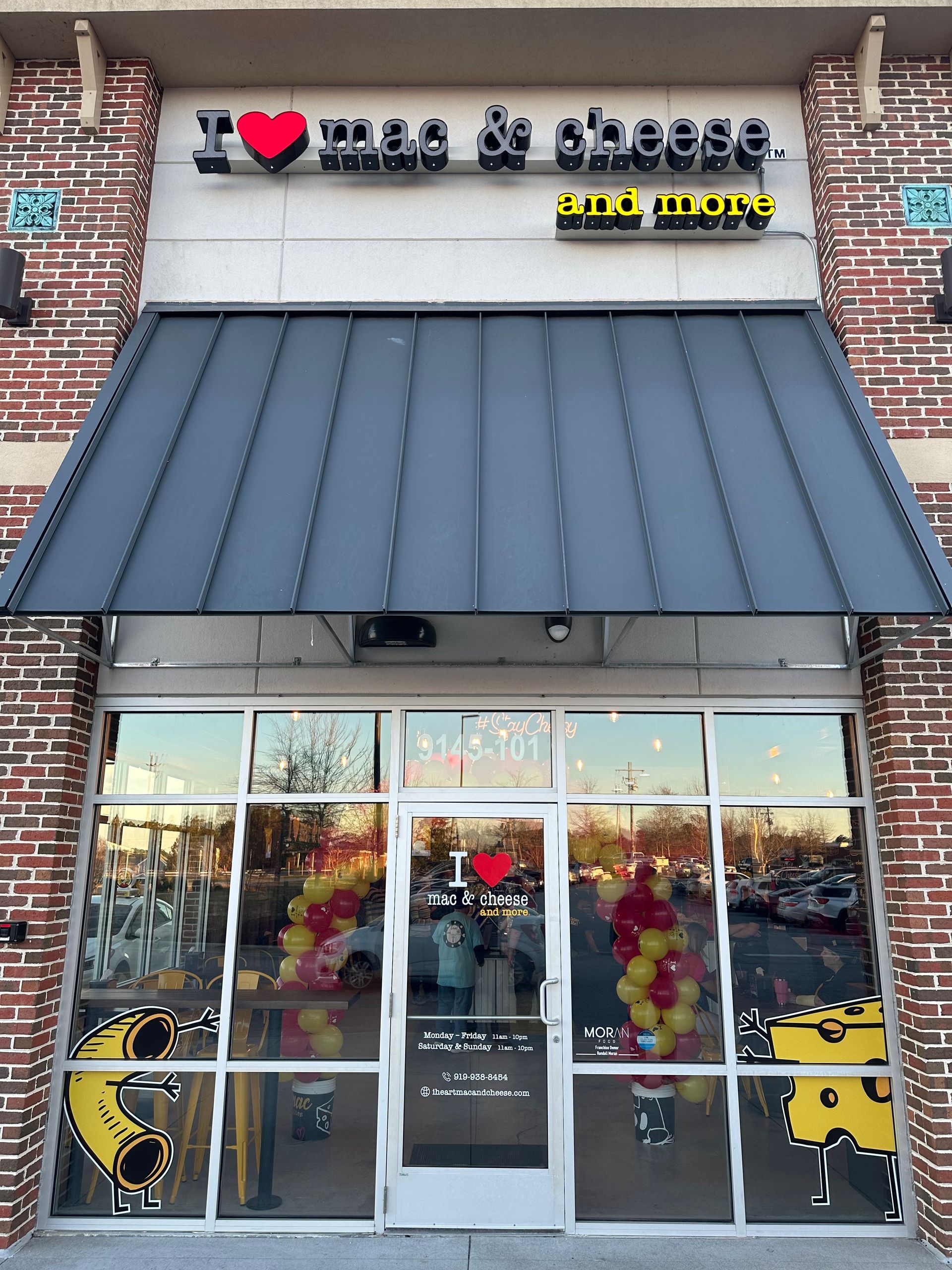 A store front with a sign that says I Love Mac and Cheese