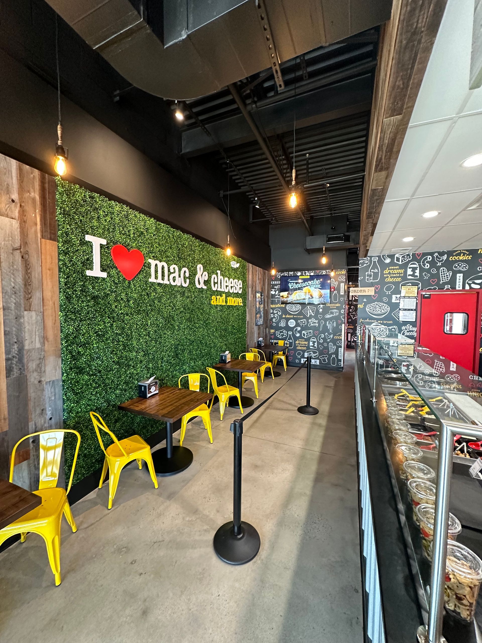 A restaurant with tables and chairs and a wall that says