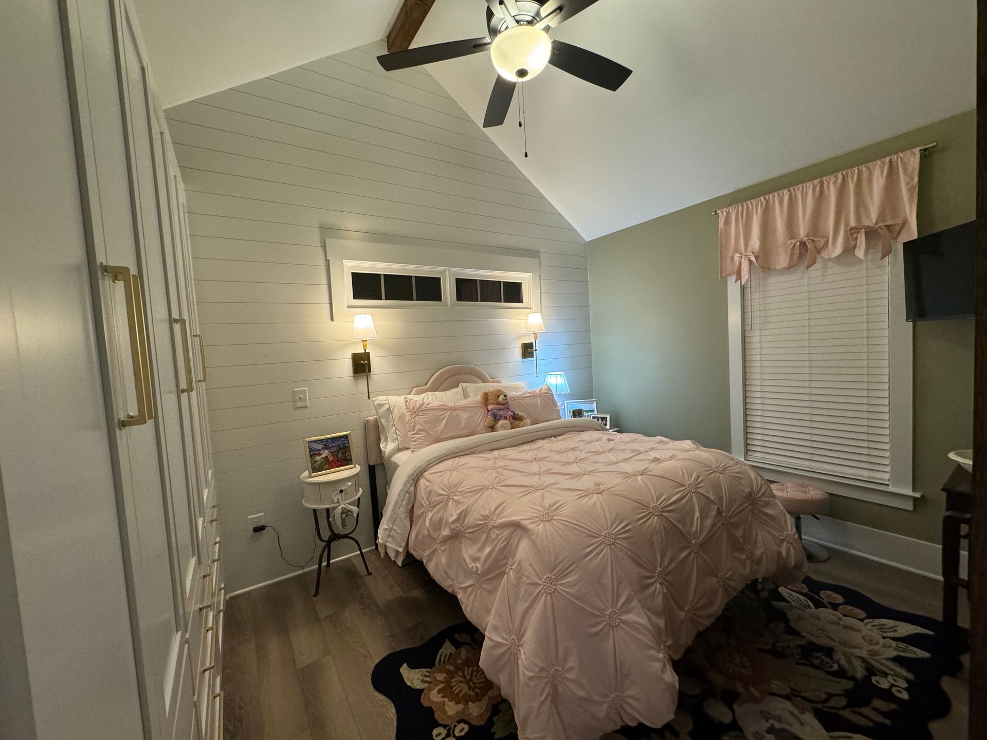 A bedroom with a bed and a ceiling fan