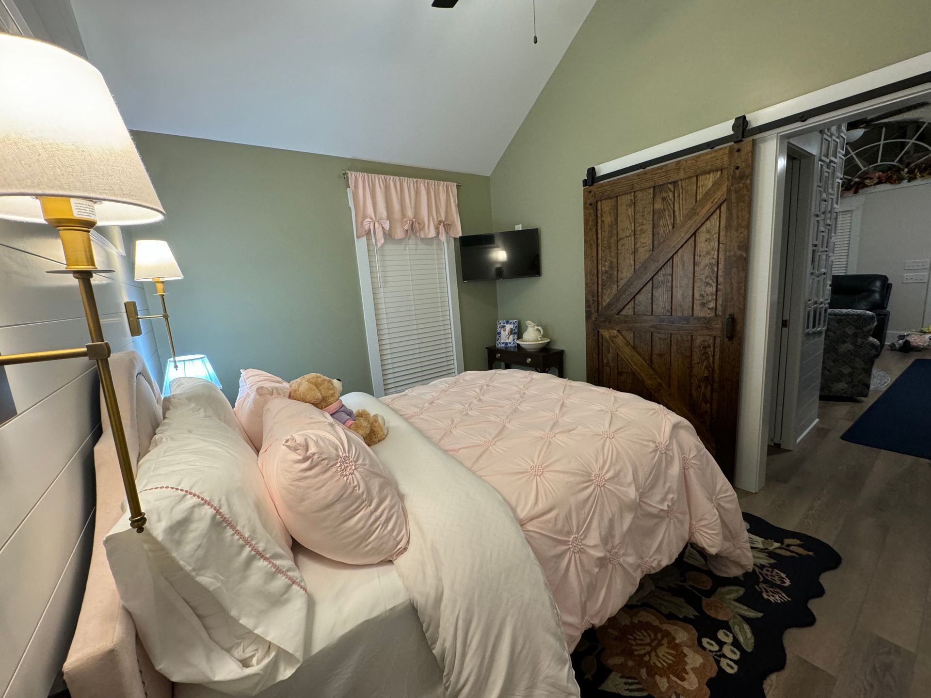 A bedroom with a bed and a sliding barn door
