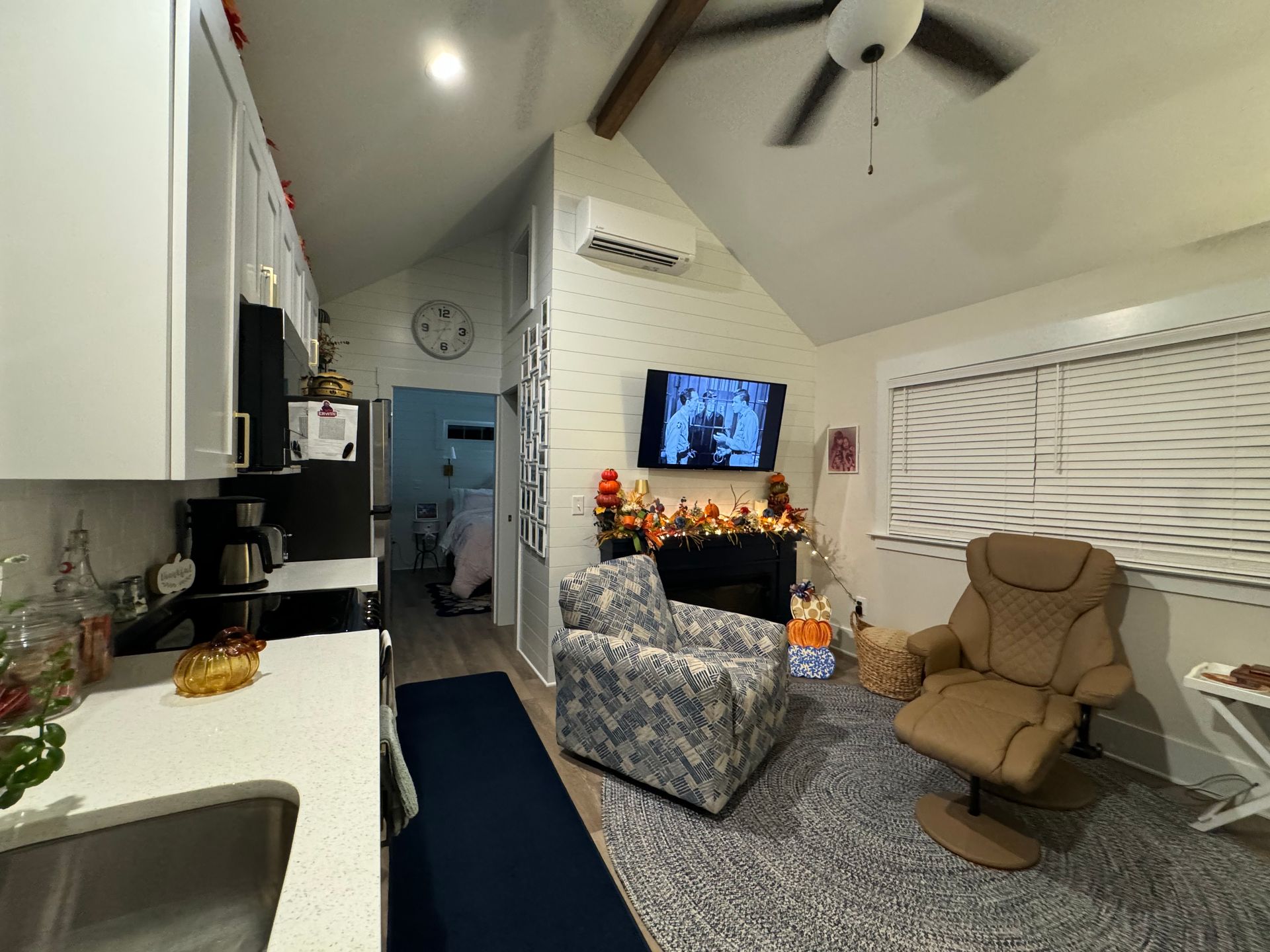 A living room with a chair and a television on the wall