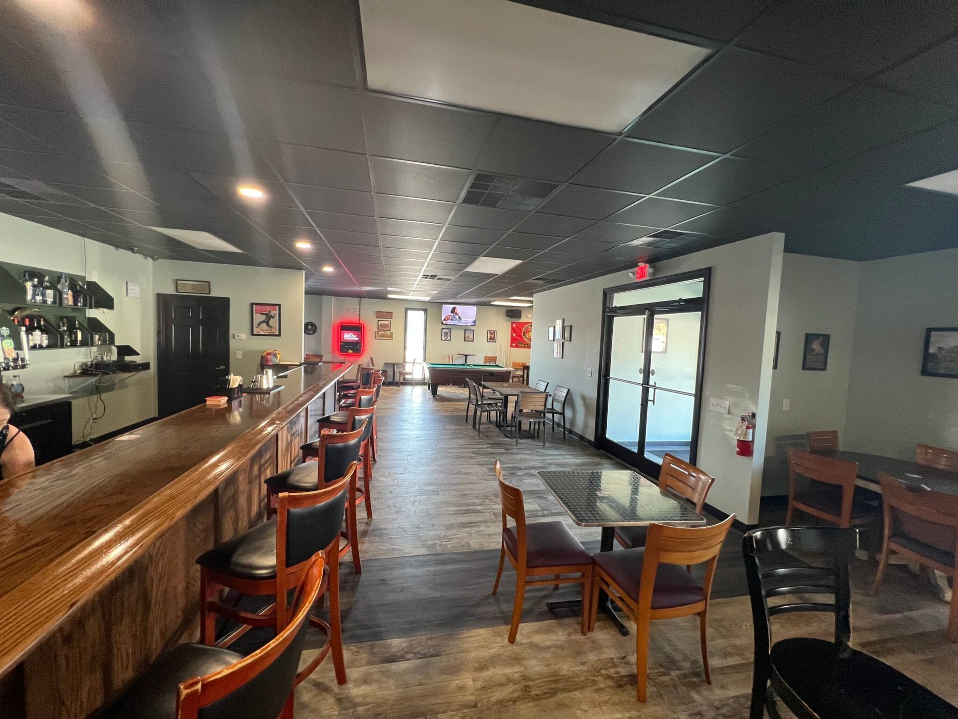 A restaurant with tables and chairs and a bar.