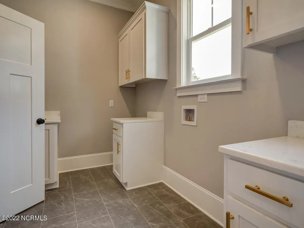 A laundry room with a washer and dryer and a window.