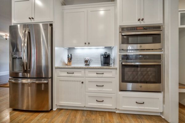 A kitchen with stainless steel appliances and white cabinets