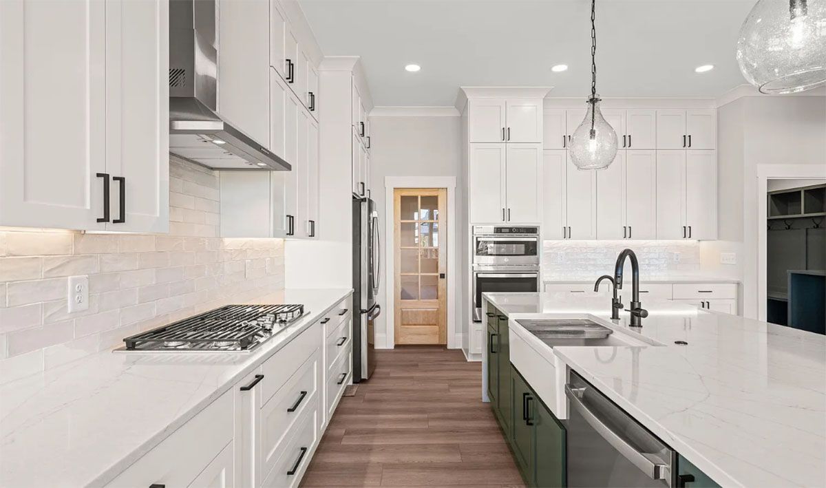 A kitchen with white cabinets and stainless steel appliances
