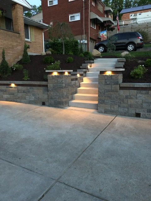 A brick wall with stairs leading up to a house