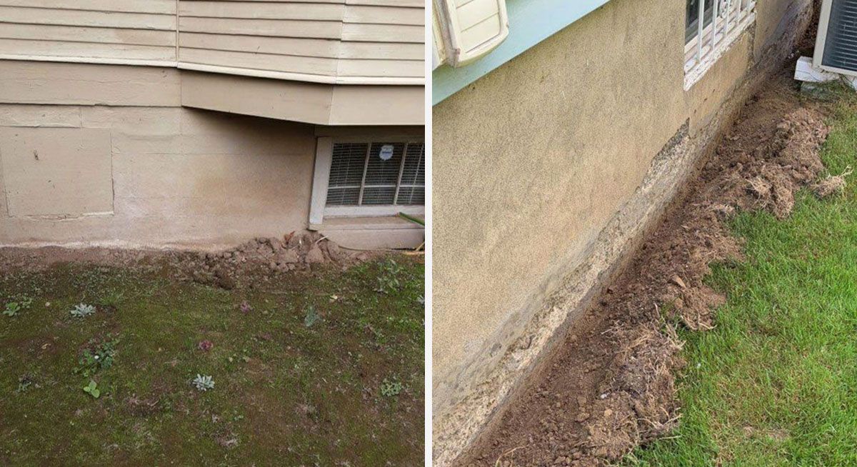 Dirt along the foundation of a house. Tan stucco, grass, small window.