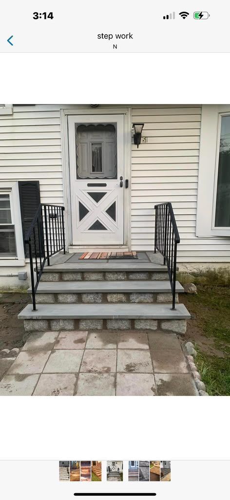 Small white front porch with steps, railing, and a screen door on a beige house.