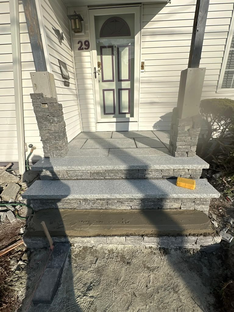 Front steps leading to a white house entrance with a gray door and house number 29