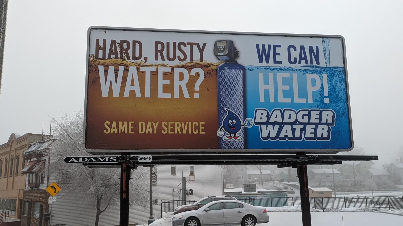 A billboard that says hard rusty water we can help badger water