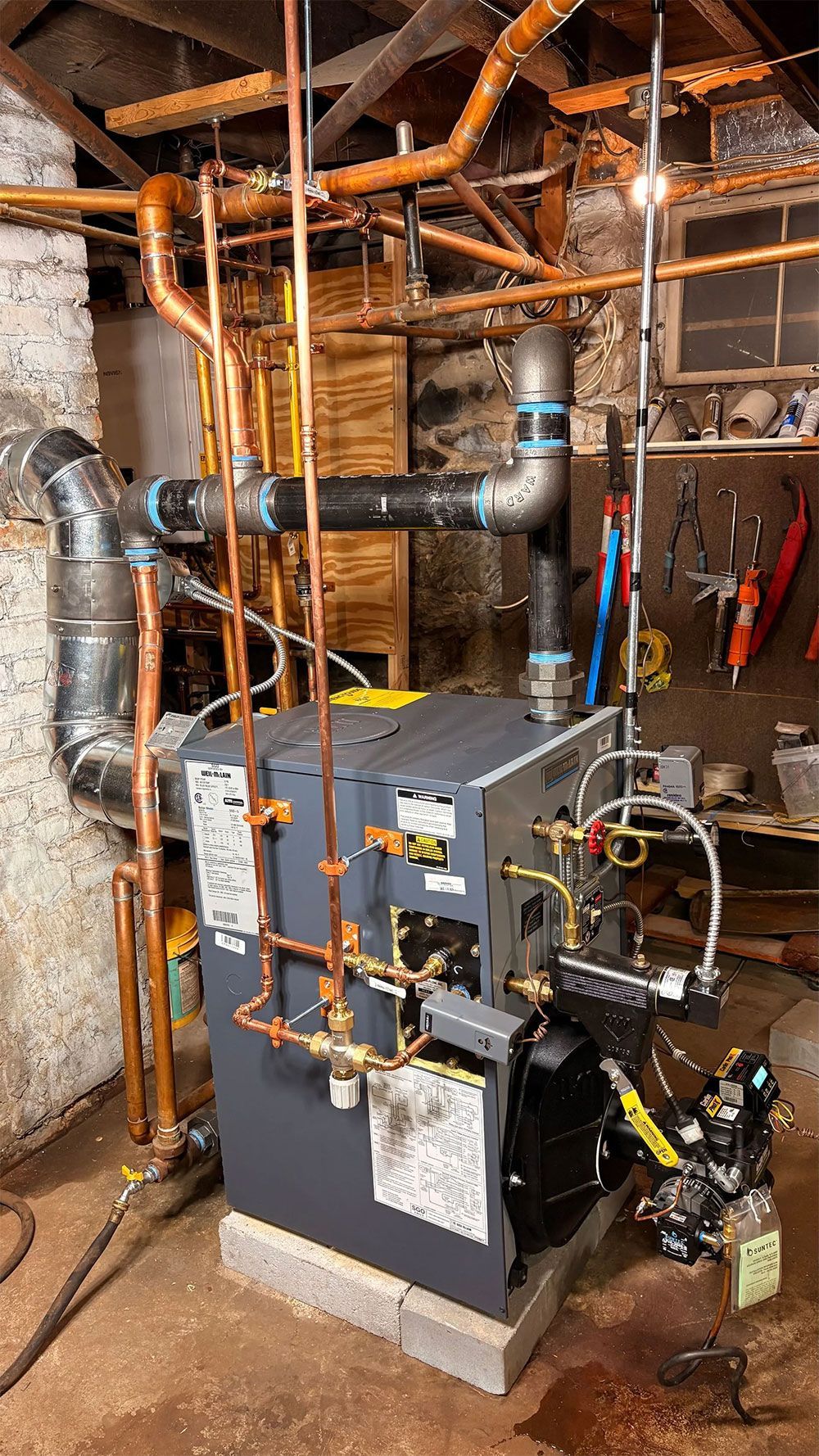 Copper pipes and a boiler in a basement.