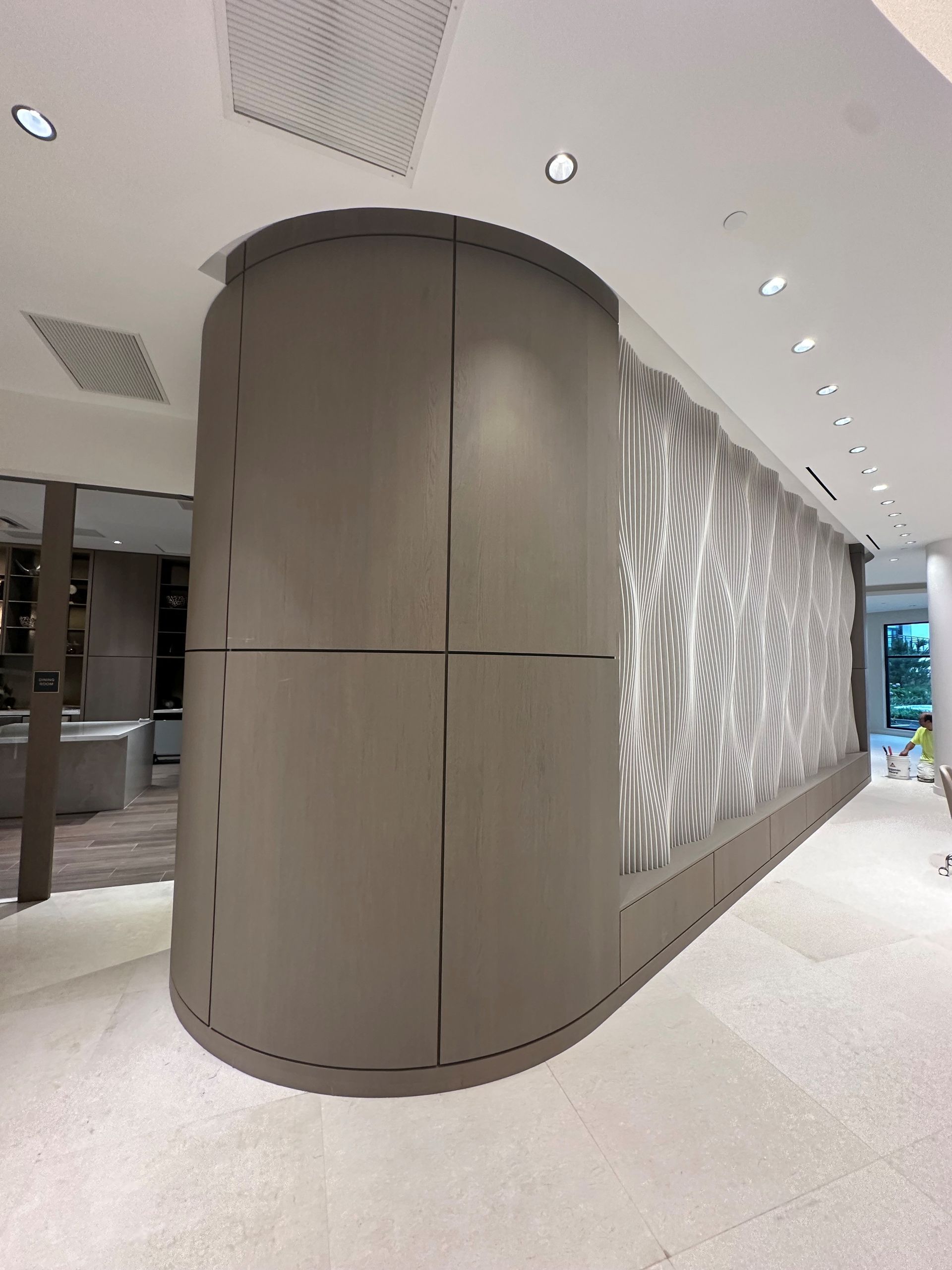 Two-story house with new gray siding and a wooden deck under construction; overcast sky.