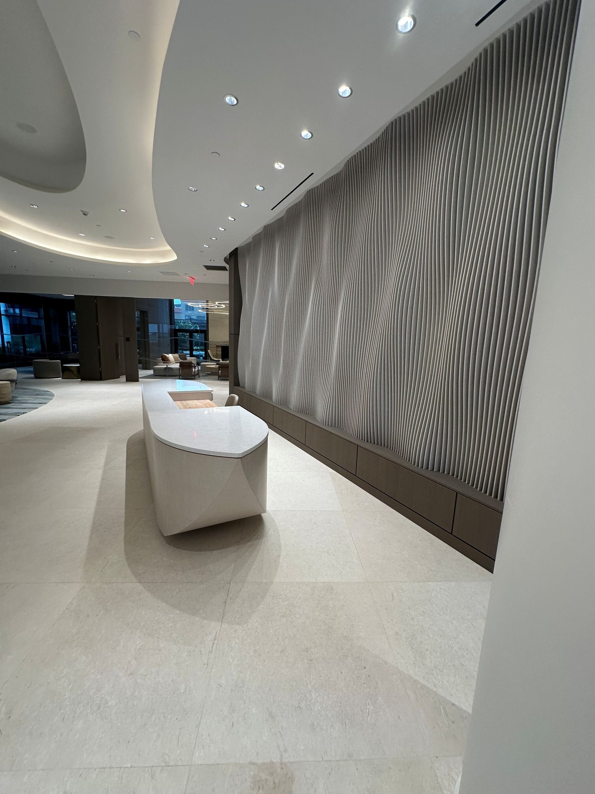White kitchen with island, range, and cabinets. Light fixtures and floral arrangement.