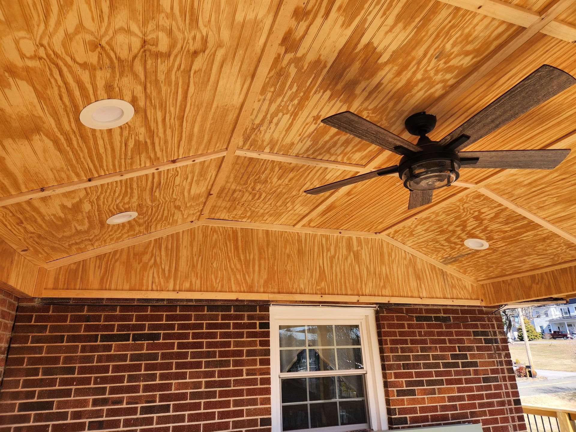 Brick patio with wood ceiling, recessed lights, and ceiling fan.