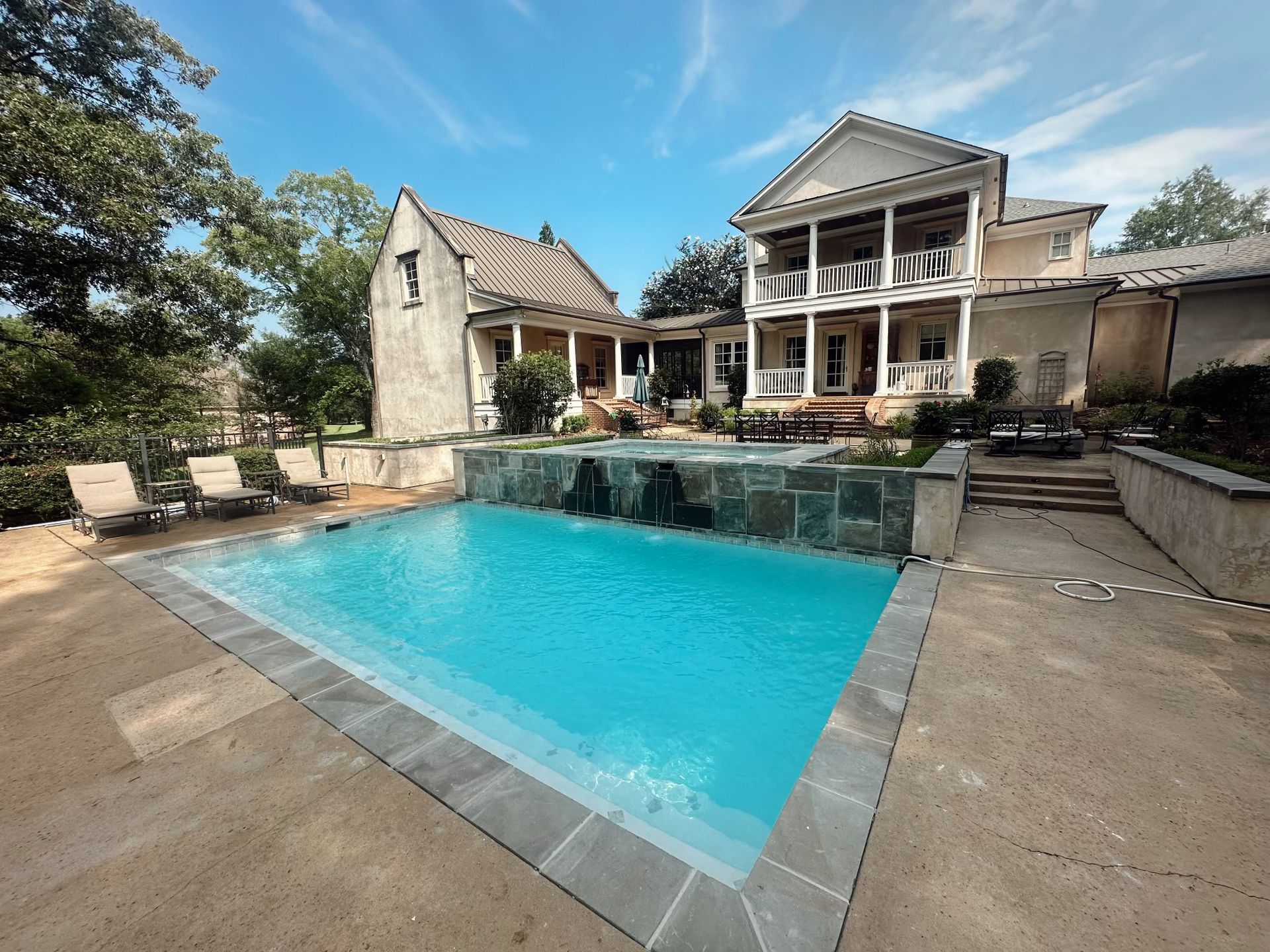A large house with a large swimming pool in front of it