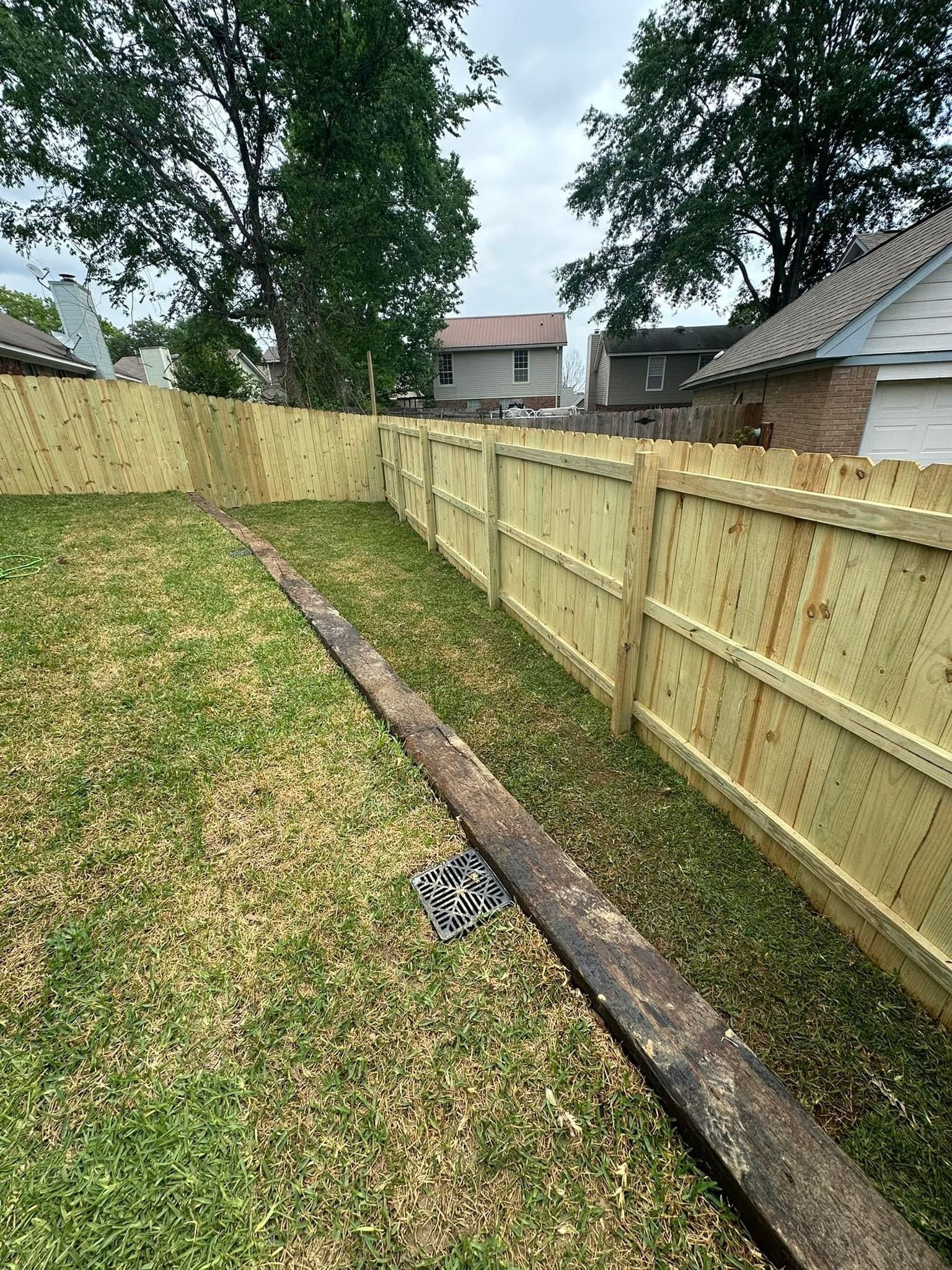 There is a wooden fence in the backyard of a house.