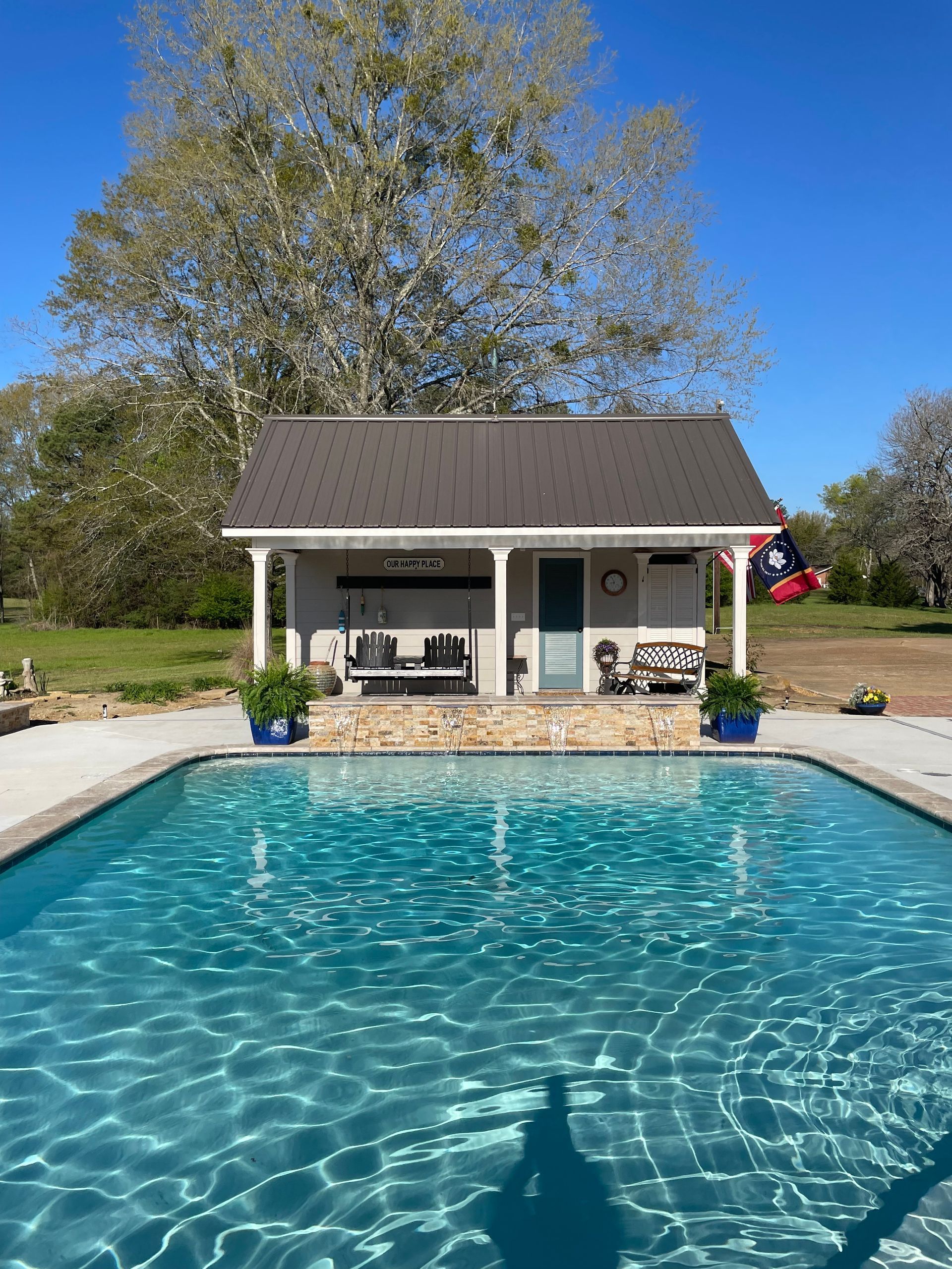 There is a large swimming pool in front of a house.