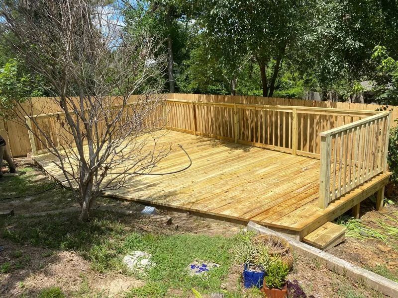 A wooden deck with a fence around it in a backyard.