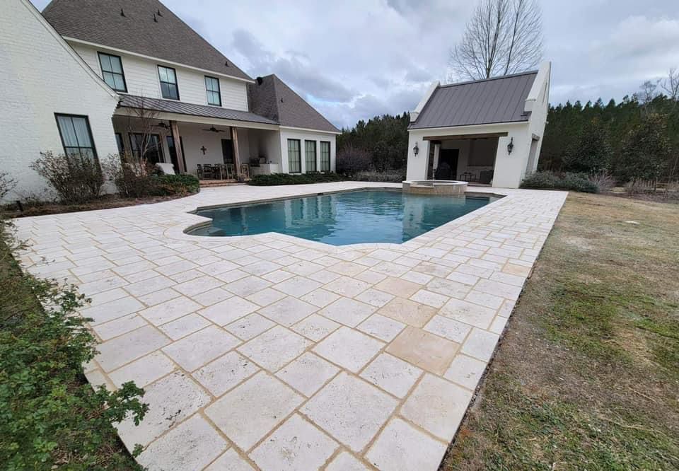 A large white house with a large swimming pool in front of it.