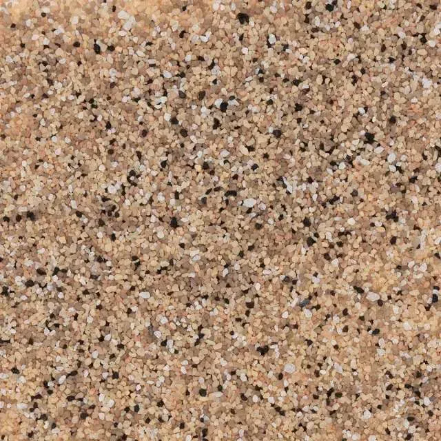 Close-up of a speckled tan and pink granite-like stone surface.