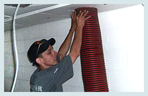 A man holding a red air duct hose