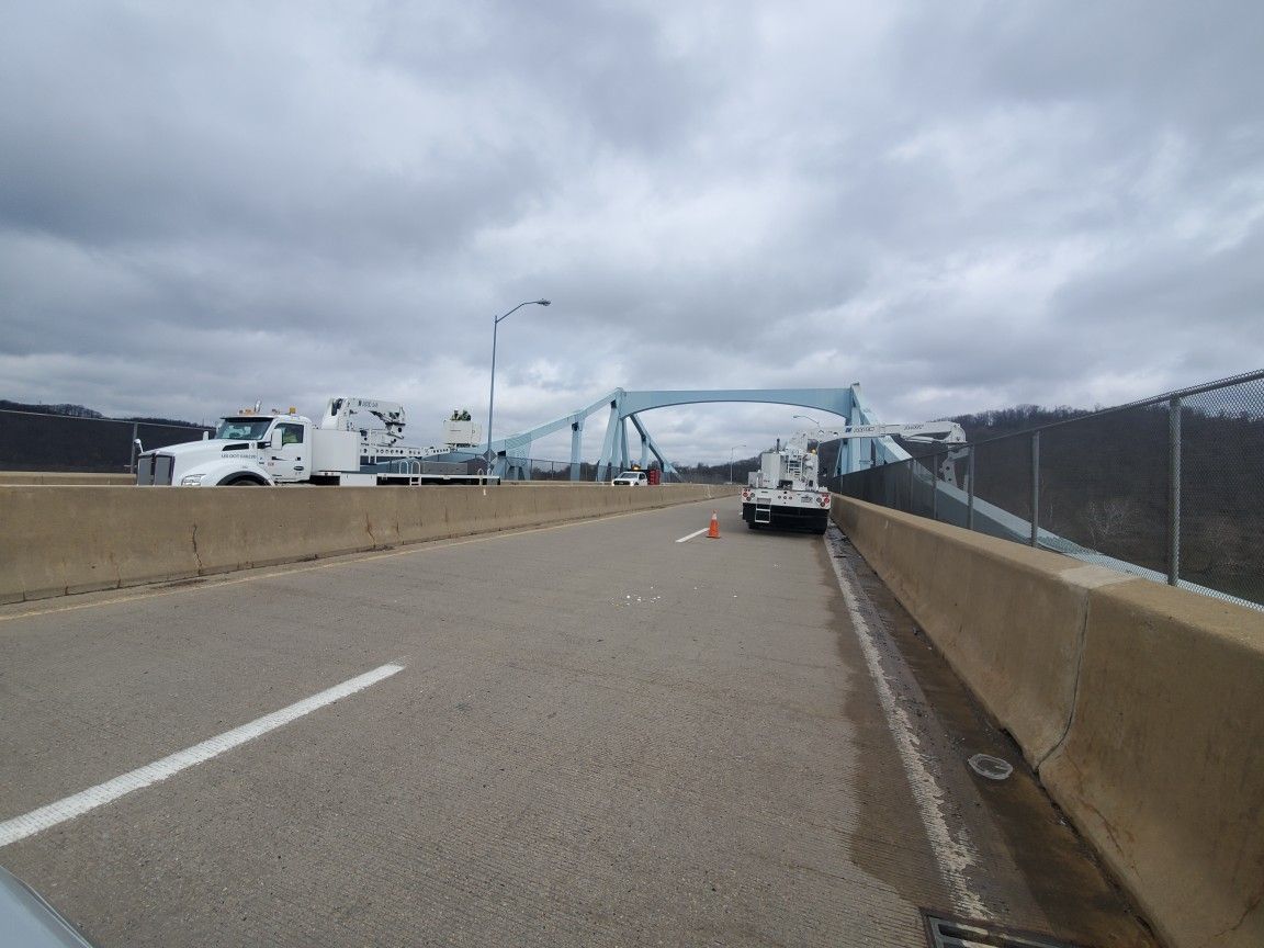 Truck is driving down a highway next to a bridge