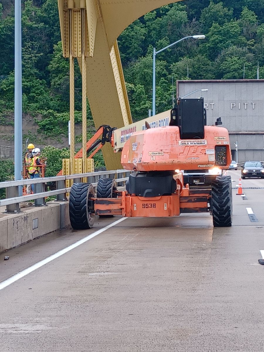A construction vehicle is driving across a bridge
