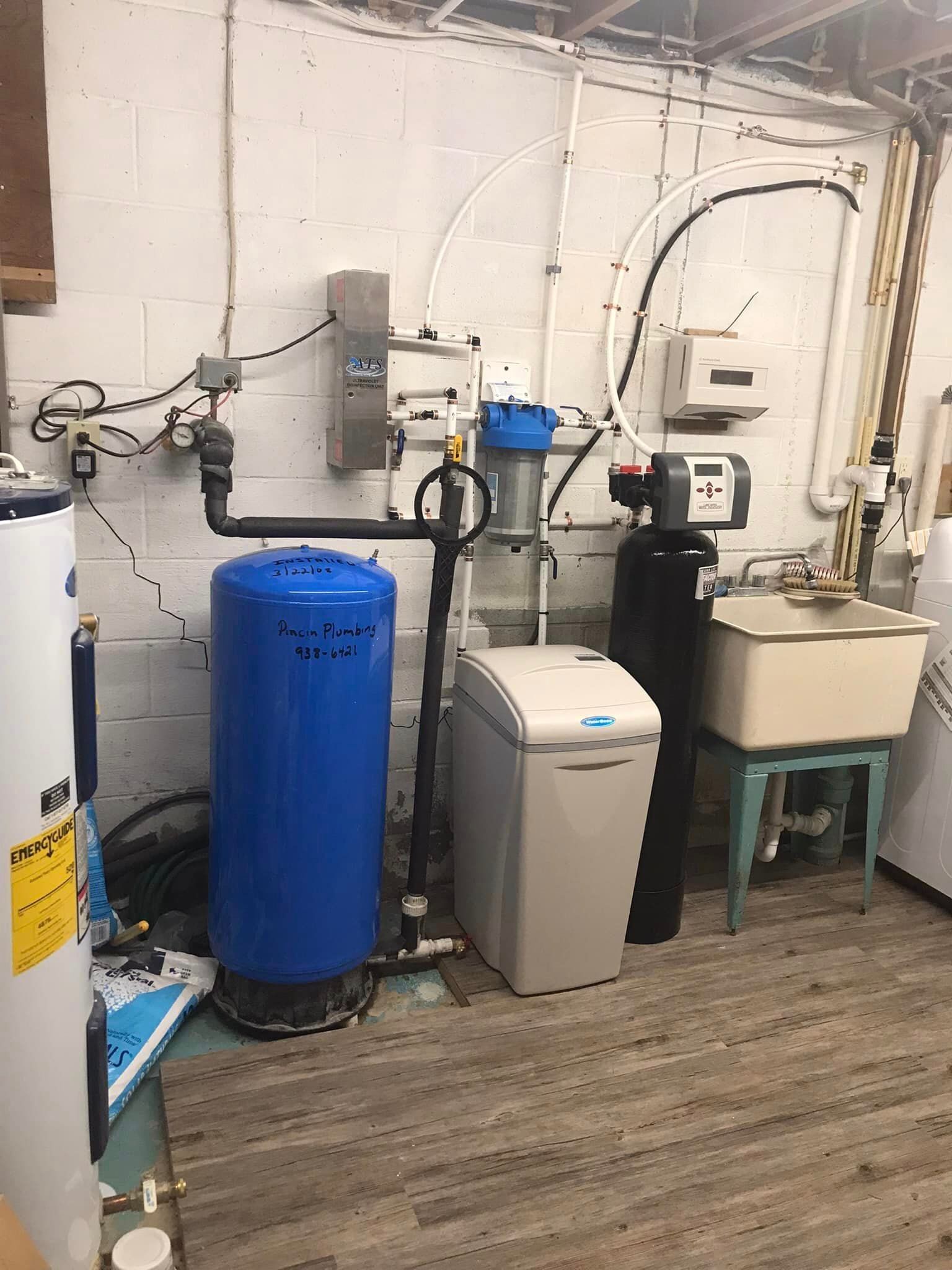 a room with a blue tank , a sink , and a heater .