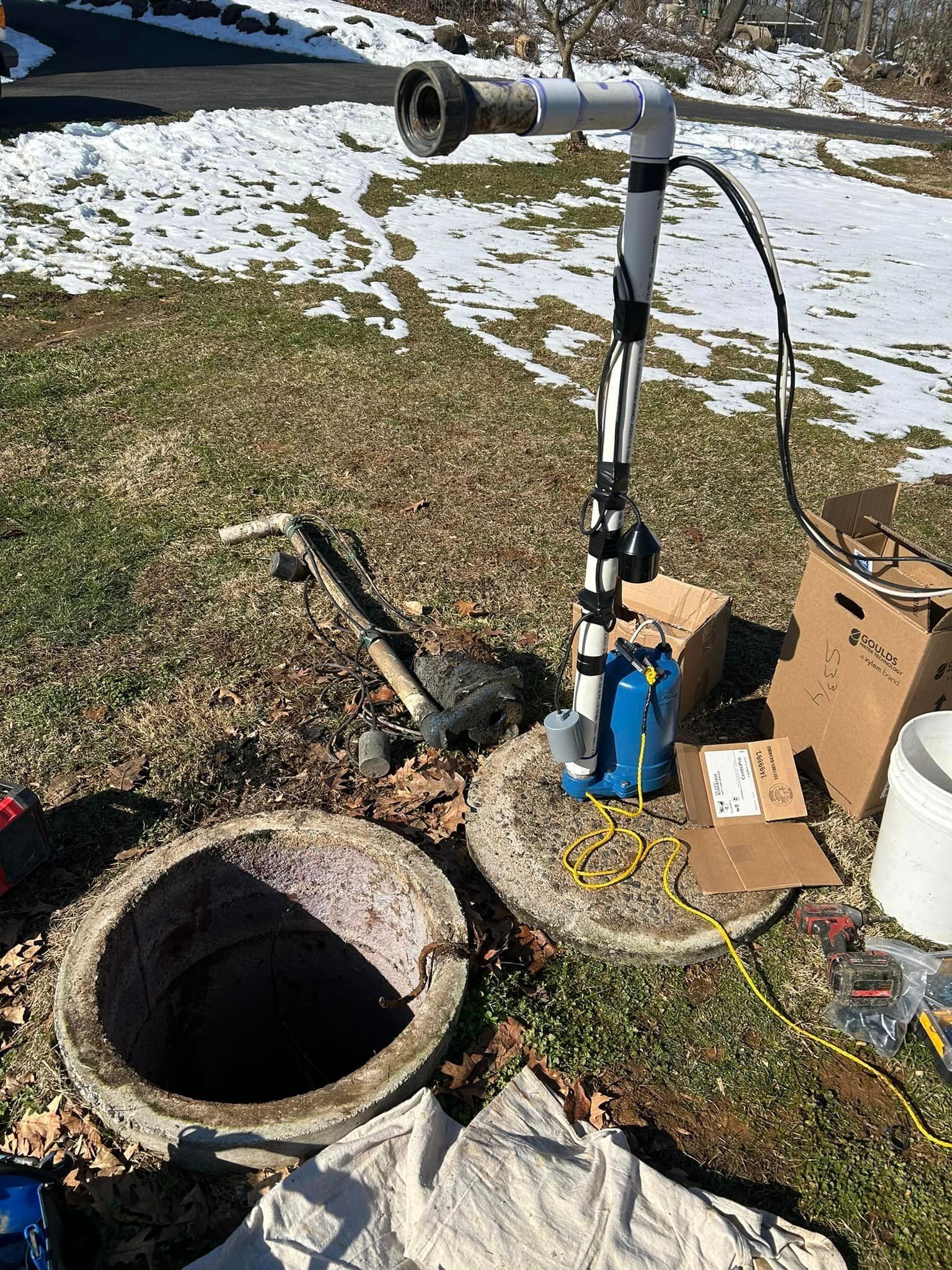 a manhole cover is sitting on the ground next to a water pump .