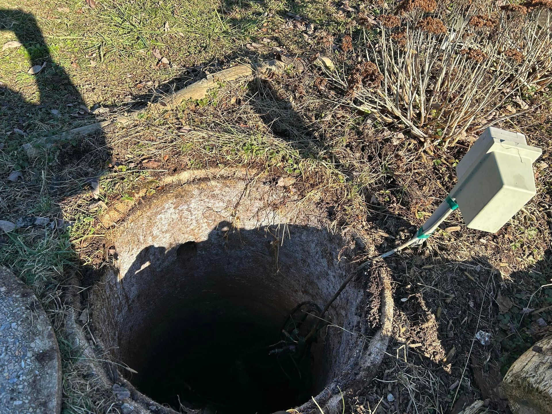 a manhole cover with a hose coming out of it .