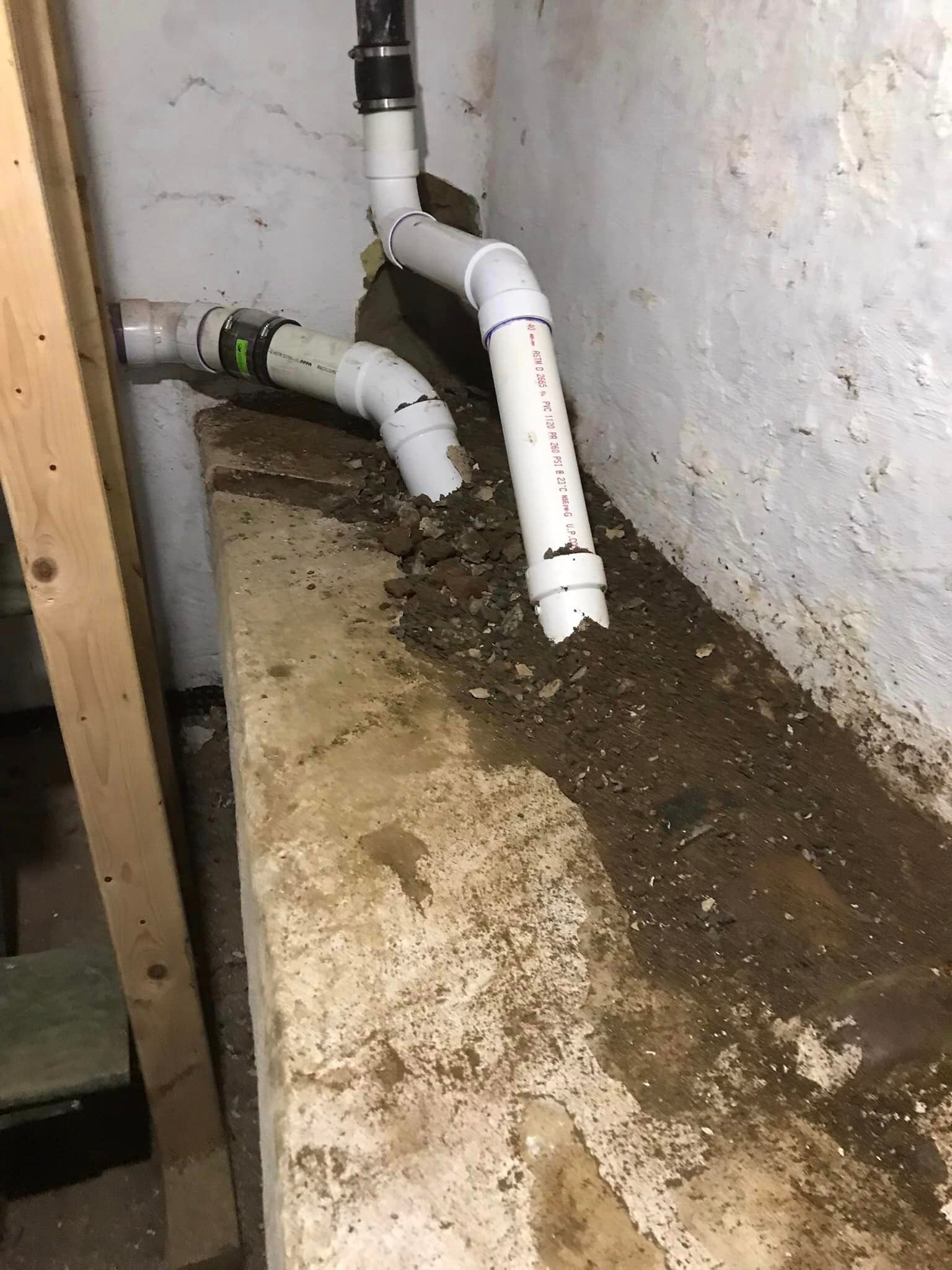 a bunch of pipes are sitting on top of a concrete wall .